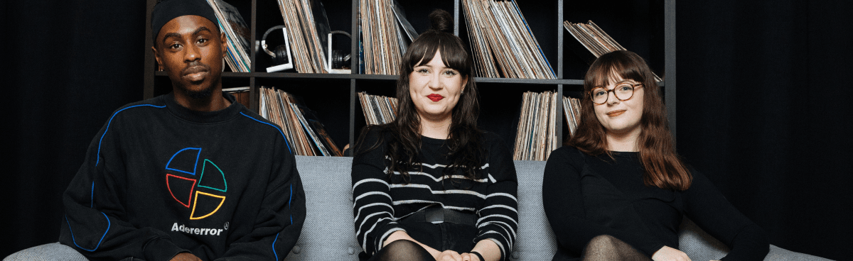 Music researchers sit in front of a collection of vinyl records