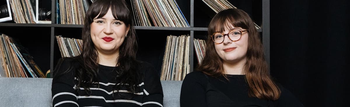 Music researchers sit in front of a collection of vinyl records